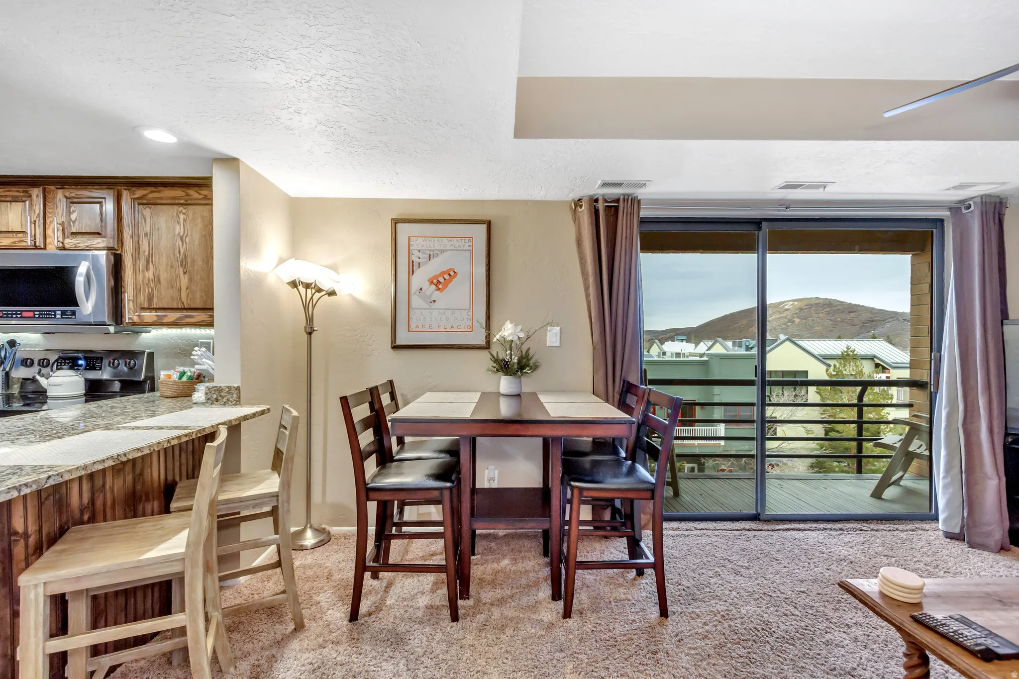 Dining space with light carpet and a textured ceiling
