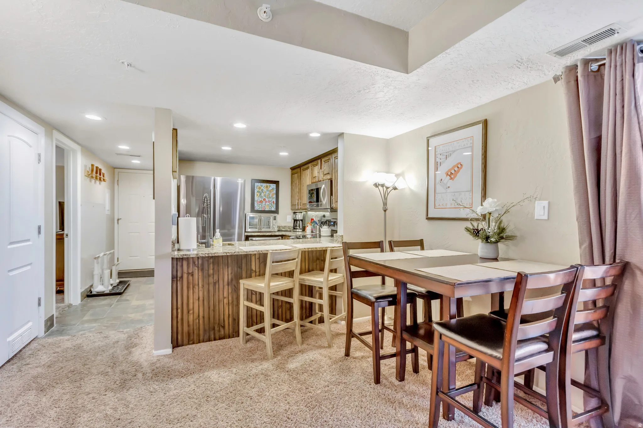 Dining room featuring light colored carpet and recessed lighting