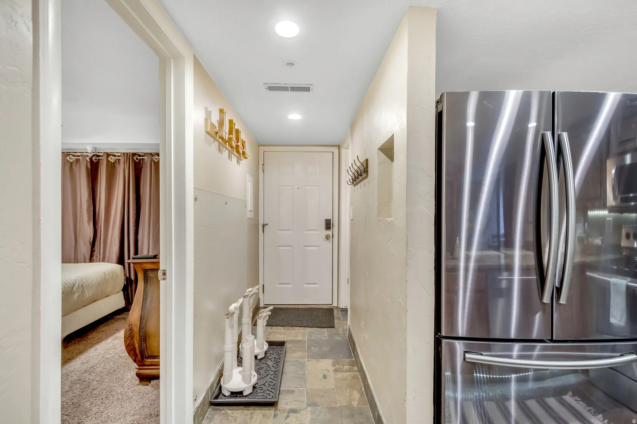 Hallway featuring light stone finish floors and recessed lighting