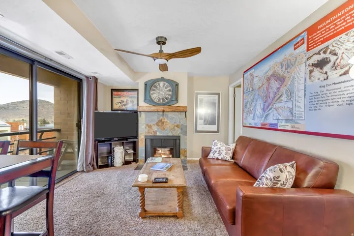 Living room with a tile fireplace, a mountain view, carpet floors, and ceiling fan