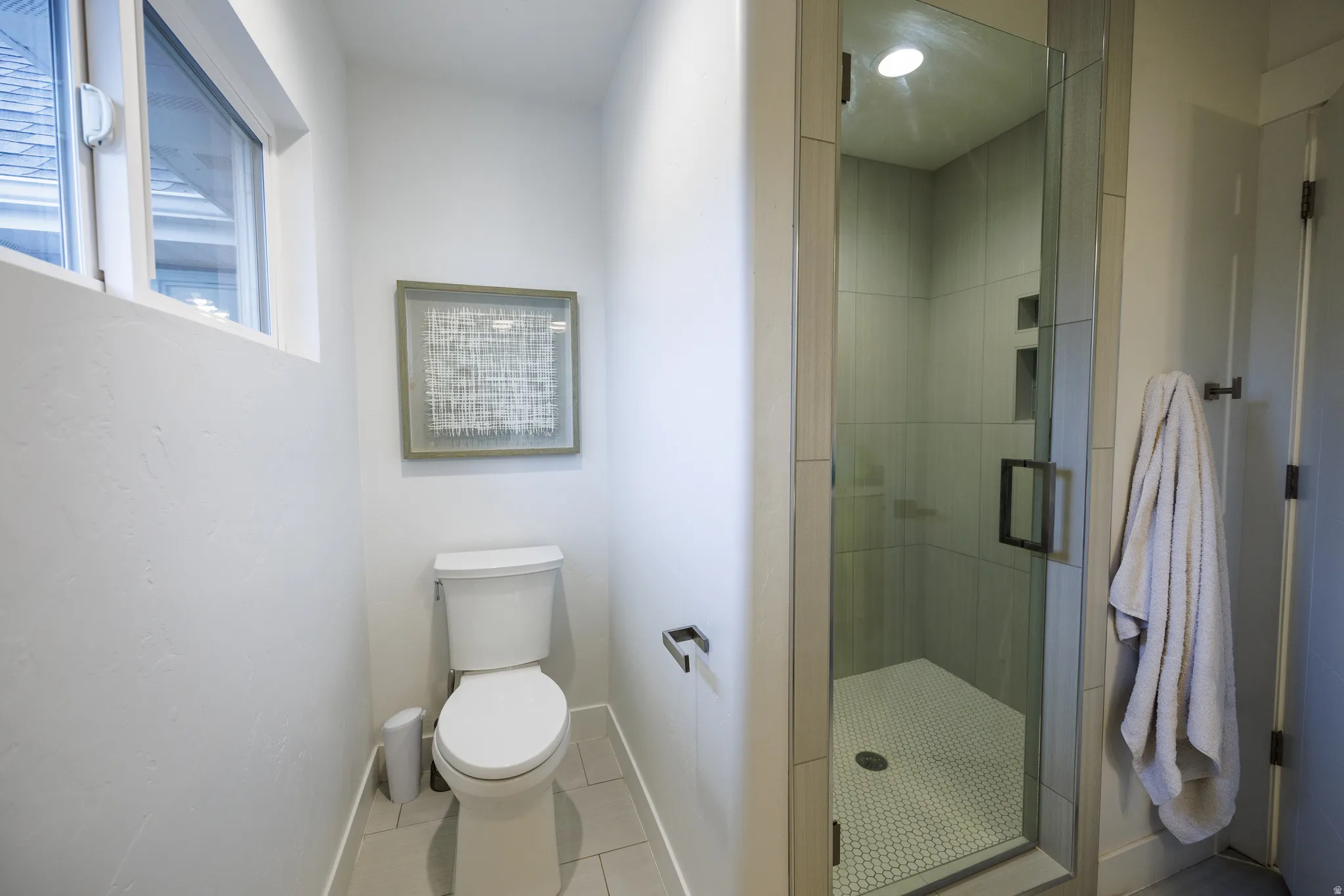 Bathroom with a stall shower and tile patterned floors