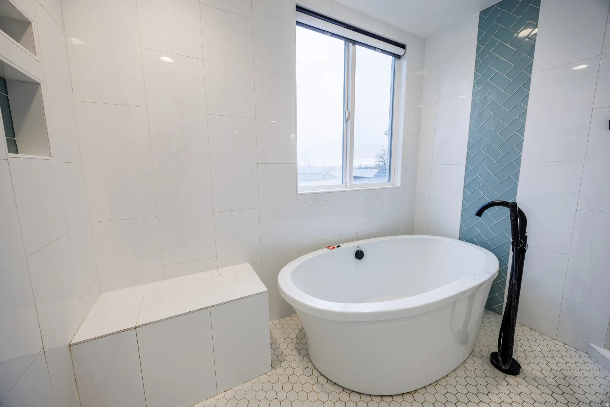 Full bathroom with a freestanding tub, tile patterned flooring, and tile walls