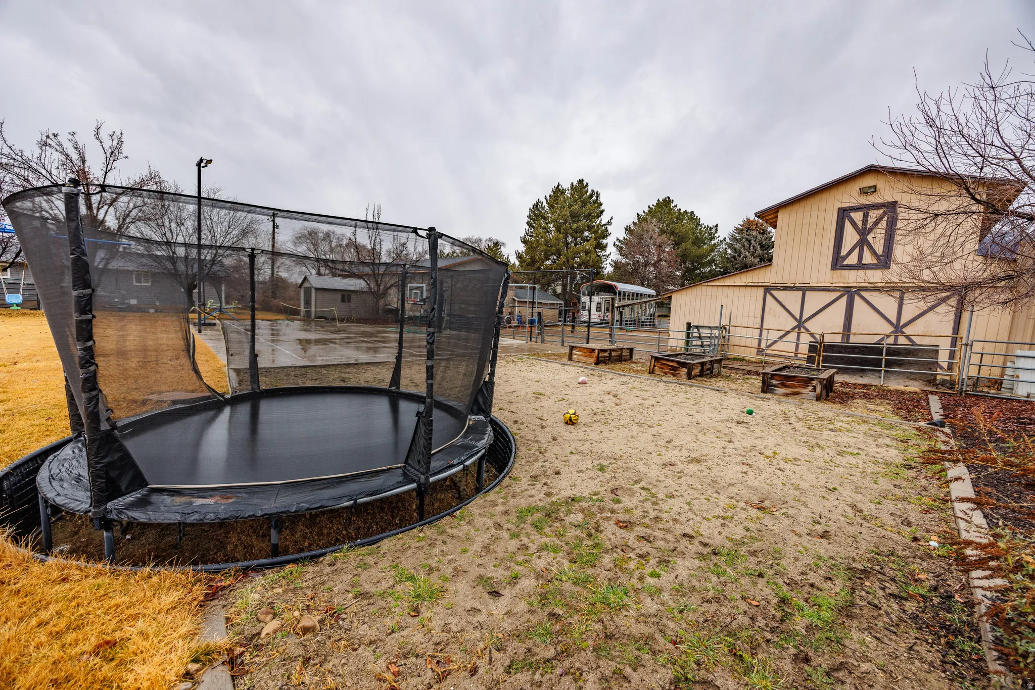 View of yard featuring a trampoline, an outdoor structure, and a barn