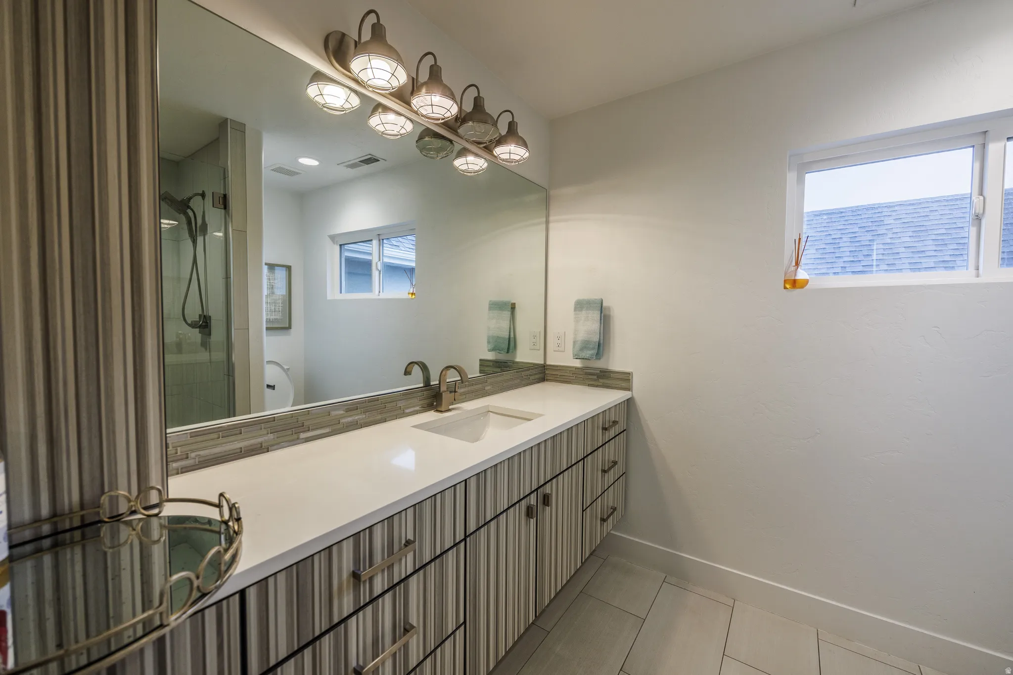 Full bathroom featuring vanity, a shower stall, and light tile patterned floors