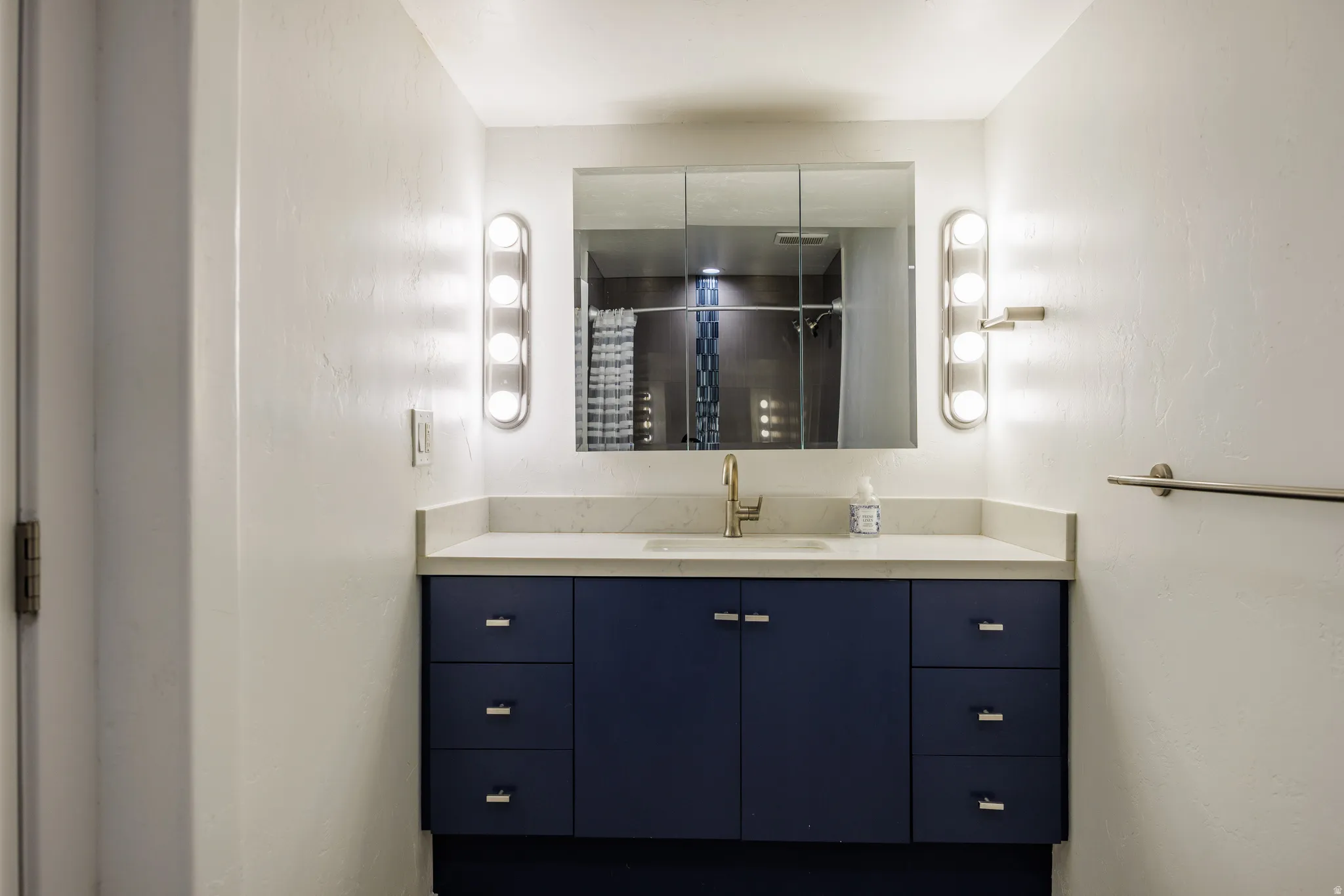 Bathroom featuring vanity and curtained shower