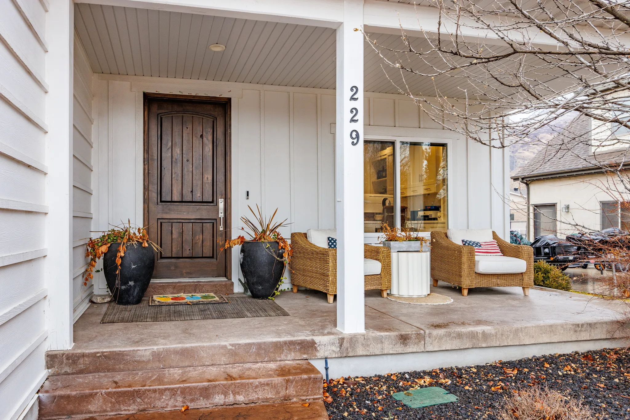 View of exterior entry featuring covered porch and board and batten siding