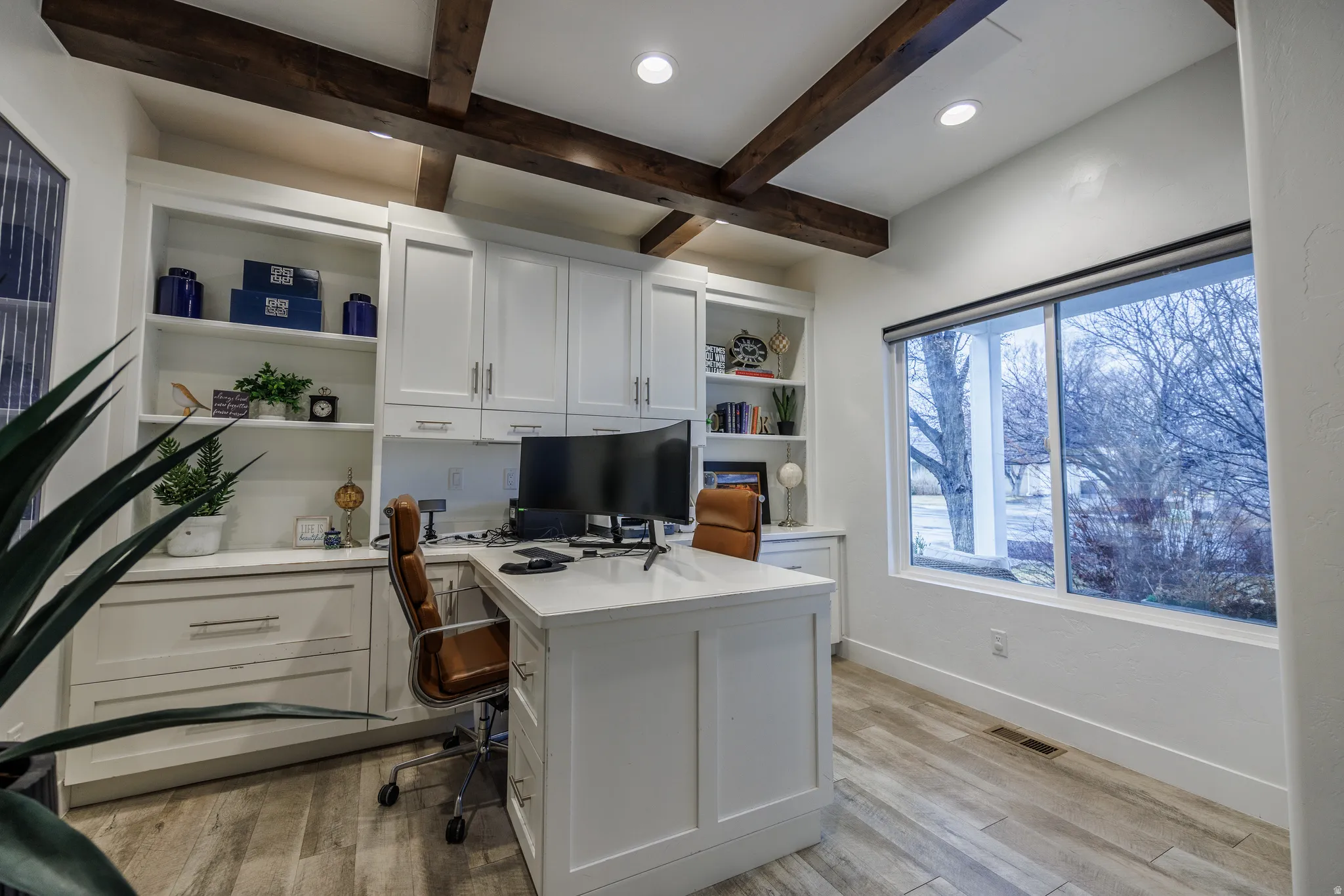 Office area featuring light wood finished floors, beamed ceiling, built in shelves, recessed lighting, and built in study area