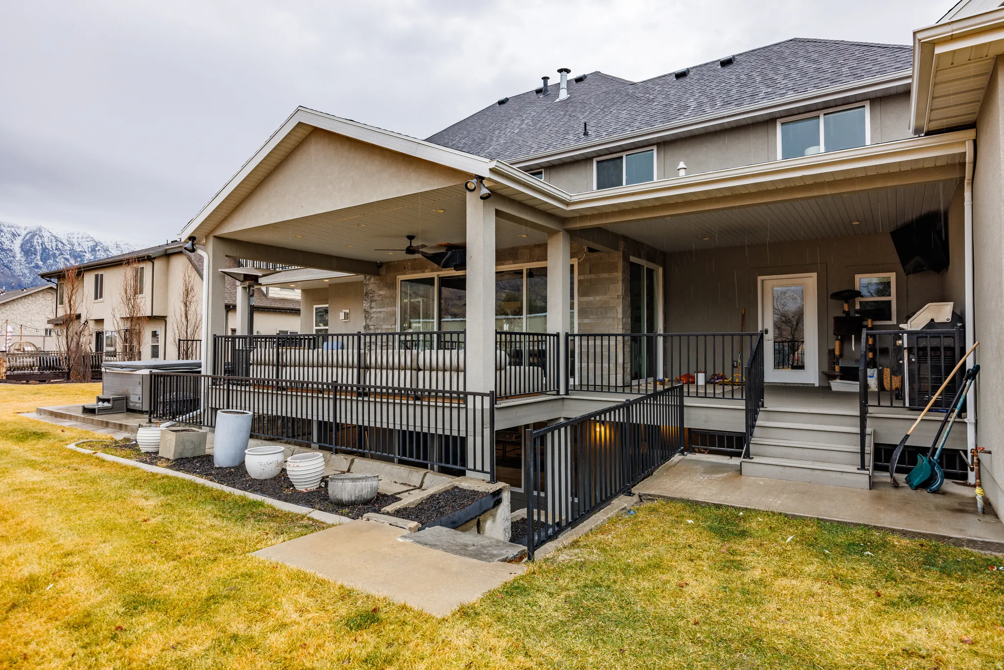 Back of house featuring a patio area, a shingled roof, a ceiling fan, and a lawn