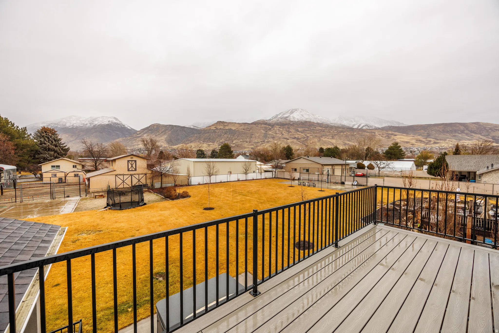 Deck with a mountain view, a residential view, and a fenced backyard