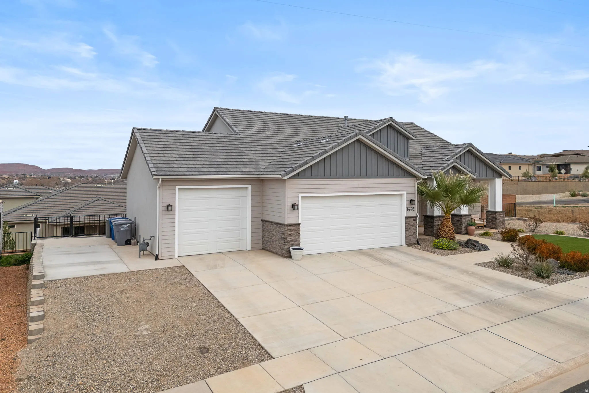 Ranch-style home with an attached garage, driveway, a residential view, and board and batten siding