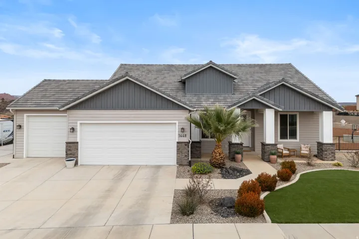 Craftsman-style home featuring stone siding, driveway, an attached garage, and a front yard