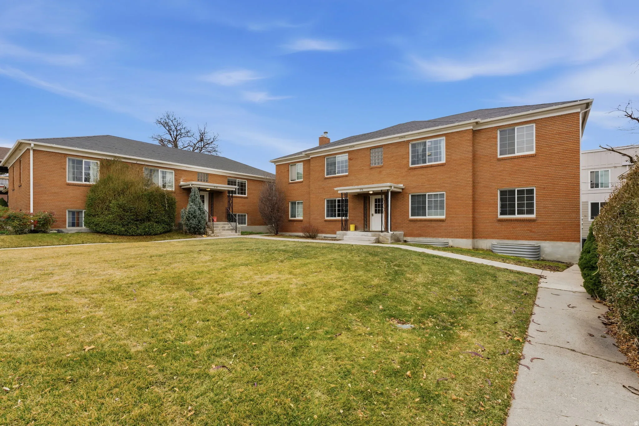 Rear view of property featuring a lawn and brick siding