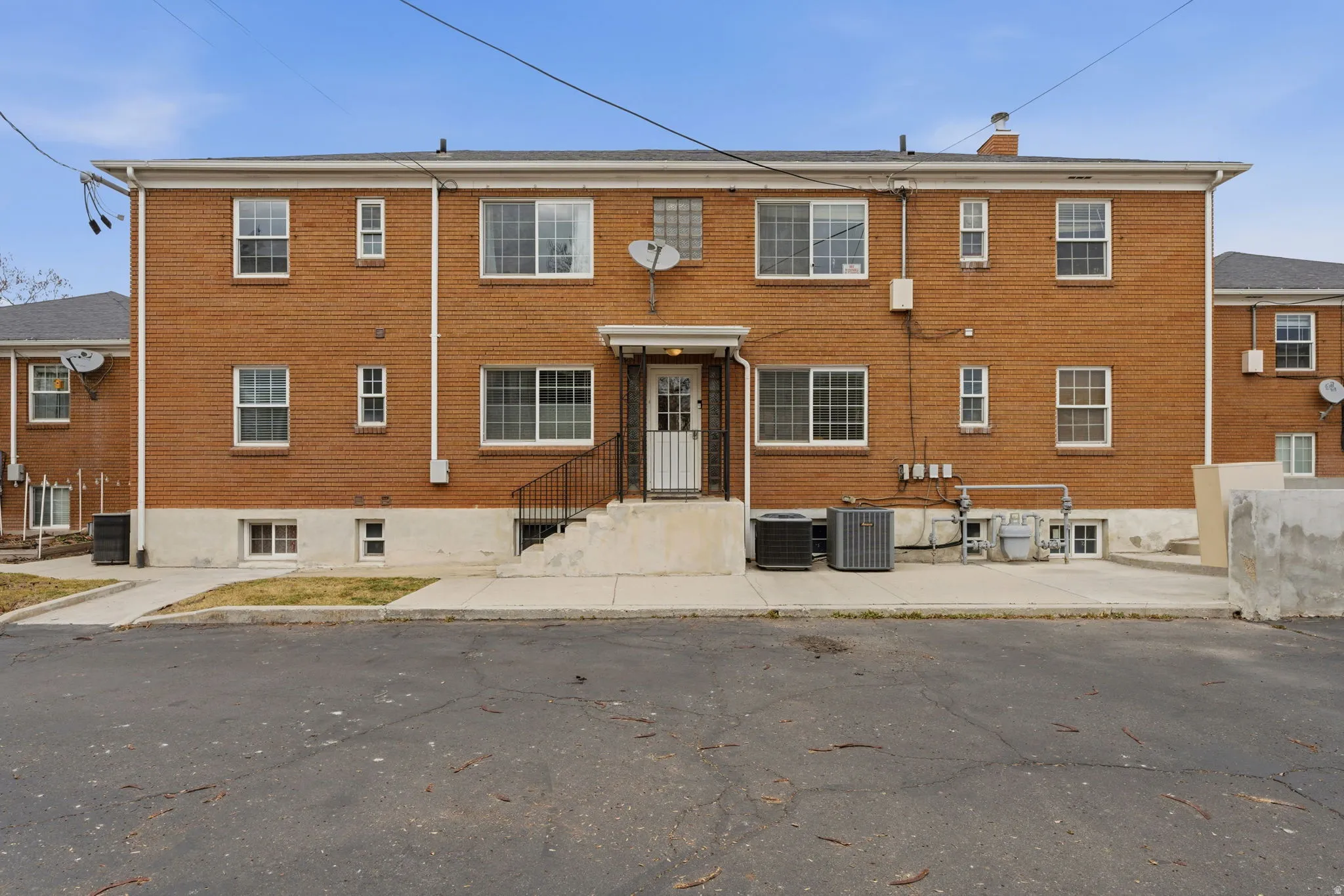 View of front facade featuring a chimney and brick siding