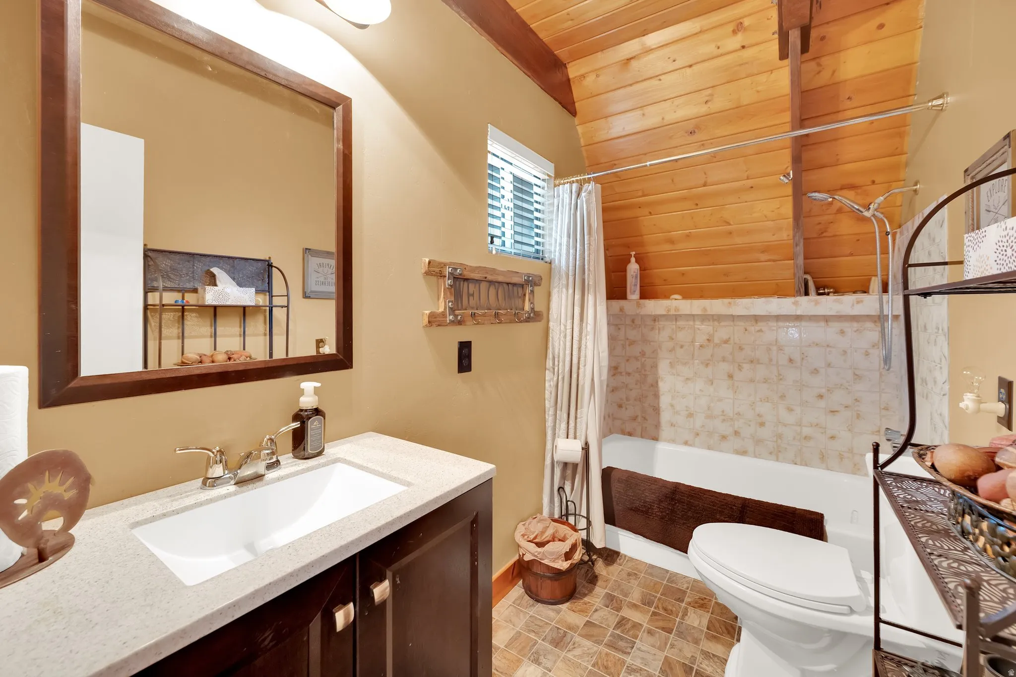 Bathroom featuring shower / tub combo, vanity, and a vaulted wood ceiling