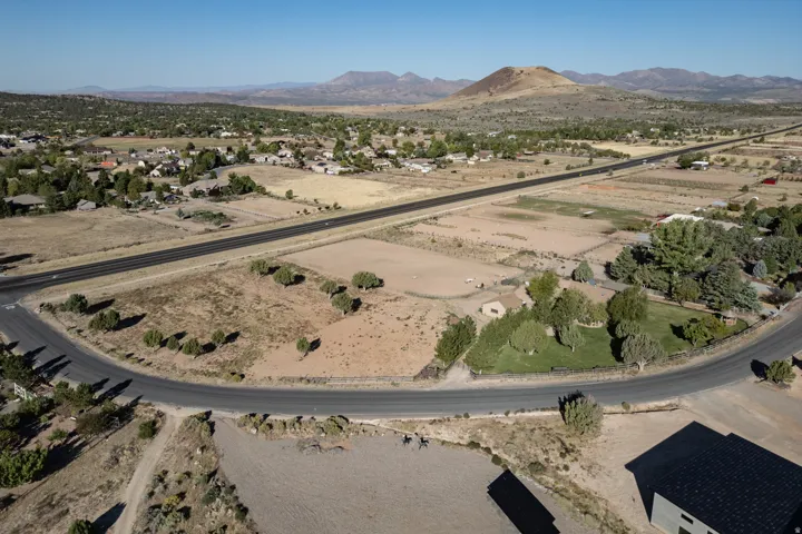 Aerial view of property and surrounding area with a mountainous background and rural landscape