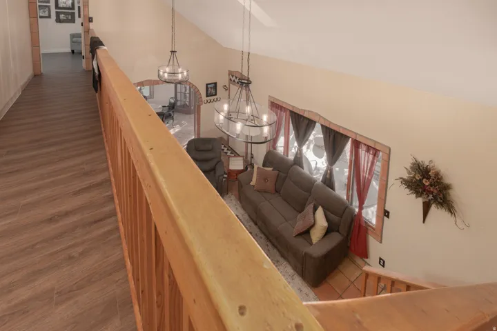 Staircase featuring hanging lights, wood finished floors, and a high ceiling