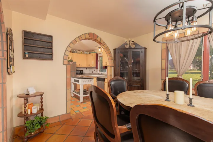 Dining room featuring suspended lighting, light tile patterned flooring, and arched walkways