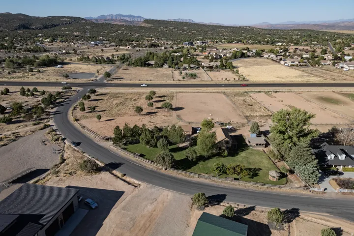 Aerial overview of property's location with a mountain backdrop, rural landscape, and nearby suburban area