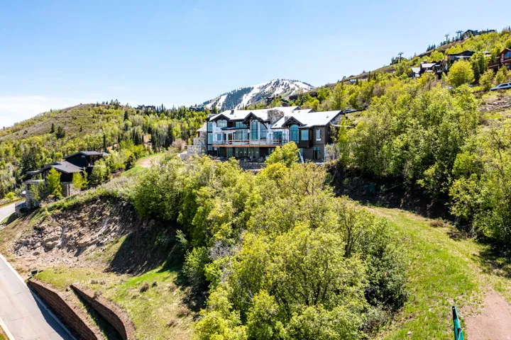 Hillside residence featuring a multi-level design with extensive balconies, stone chimney, and numerous windows