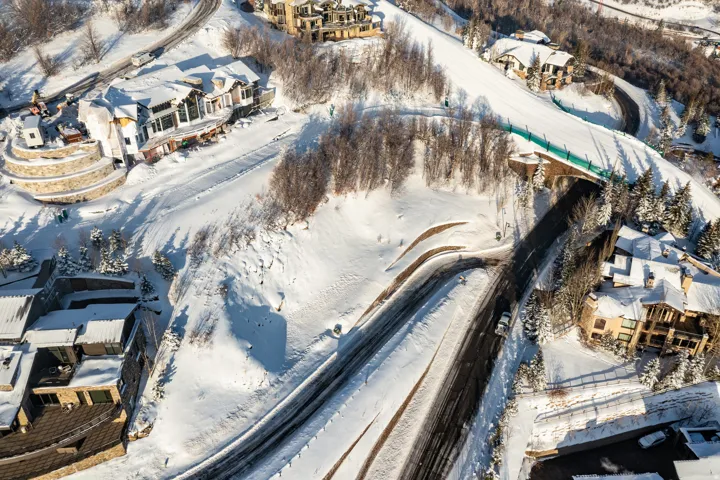 Expansive snow-covered landscape featuring multiple residential structures and paved roadways