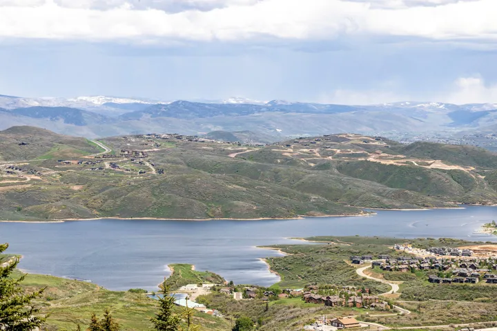 Expansive lake and mountain setting featuring rolling hillsides and residential developments