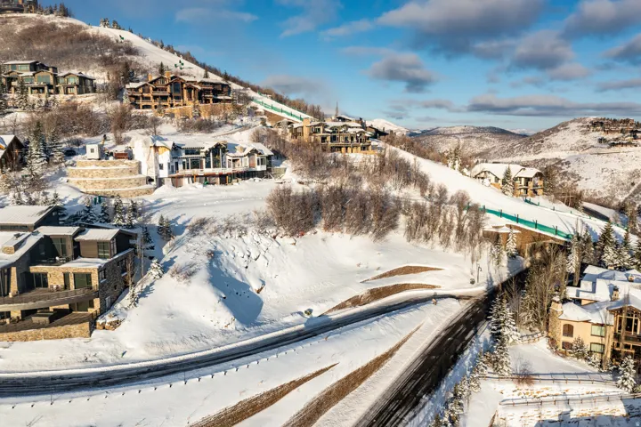 Snow-covered mountain terrain featuring multiple custom residences and a ski run