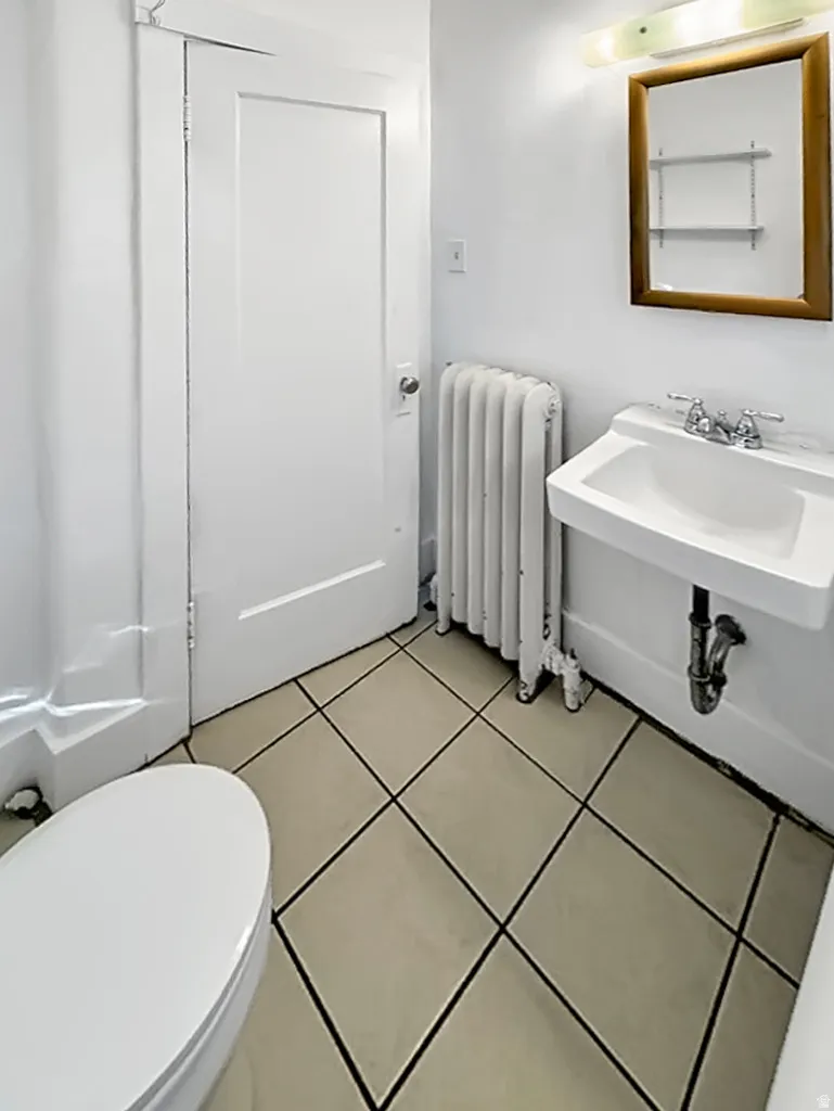 Bathroom featuring radiator and light tile patterned floors