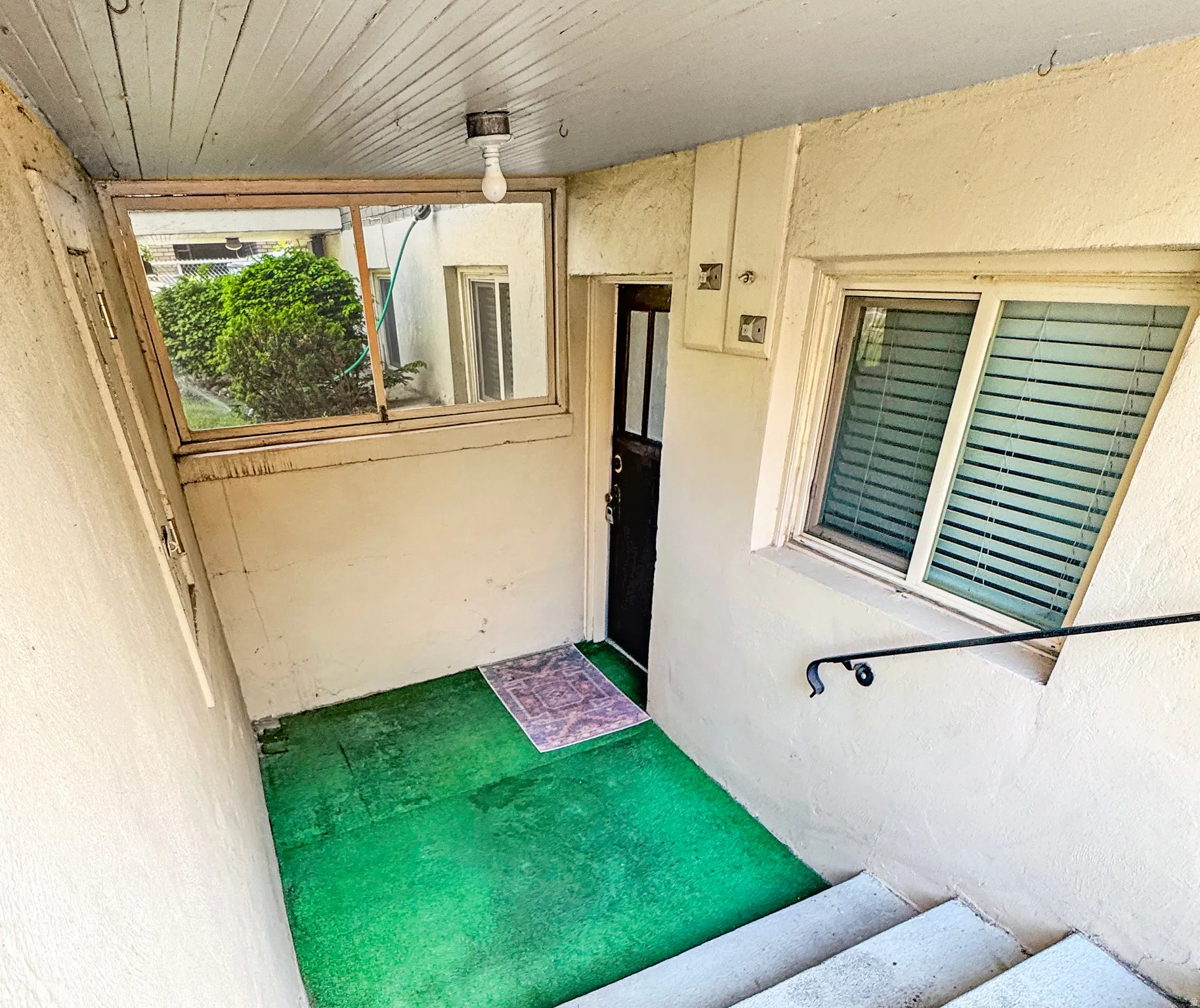 View of exterior entry featuring a sunroom