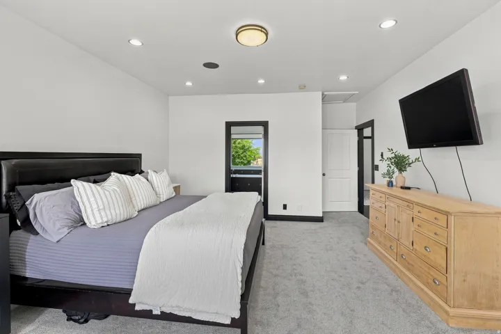 Spacious room featuring light gray carpeting and white walls