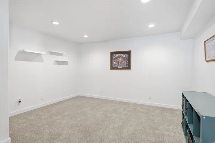 Unfurnished room with light colored carpet and recessed lighting