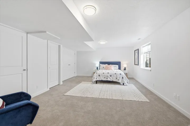 Carpeted bedroom featuring baseboards and a textured ceiling