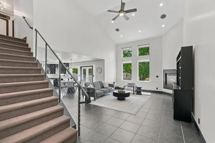 Two-story open-concept living area featuring a modern fireplace and high vaulted ceilings