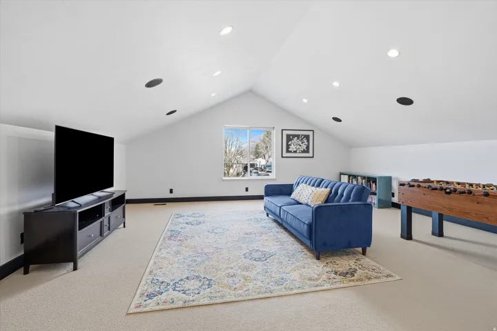 Living area with light colored carpet and recessed lighting