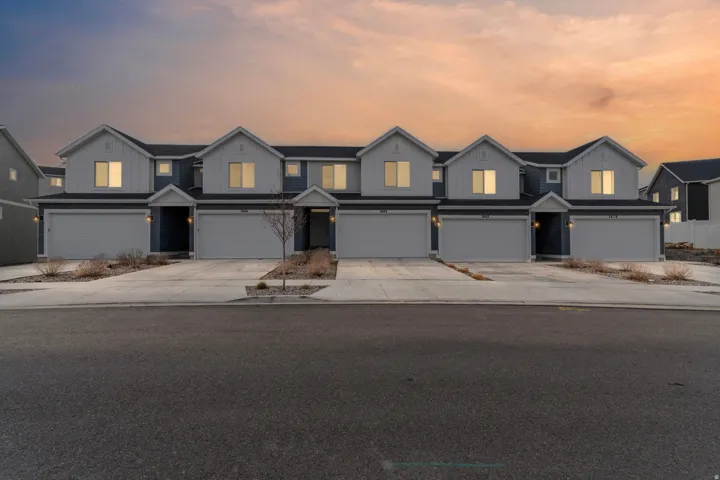 Traditional home featuring board and batten siding, driveway, and an attached garage