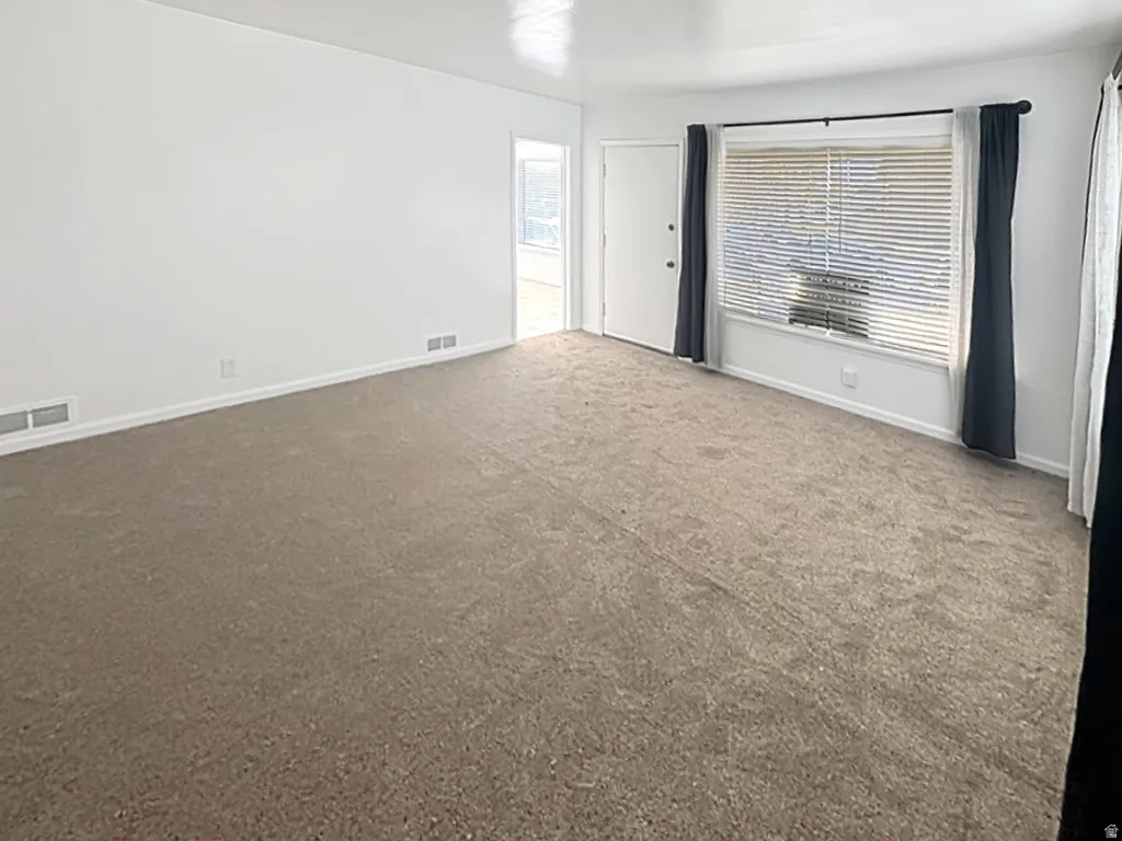 Carpeted room with healthy amount of natural light