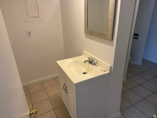 Bathroom vanity featuring a white cabinet, integrated sink, and dual-handle faucet