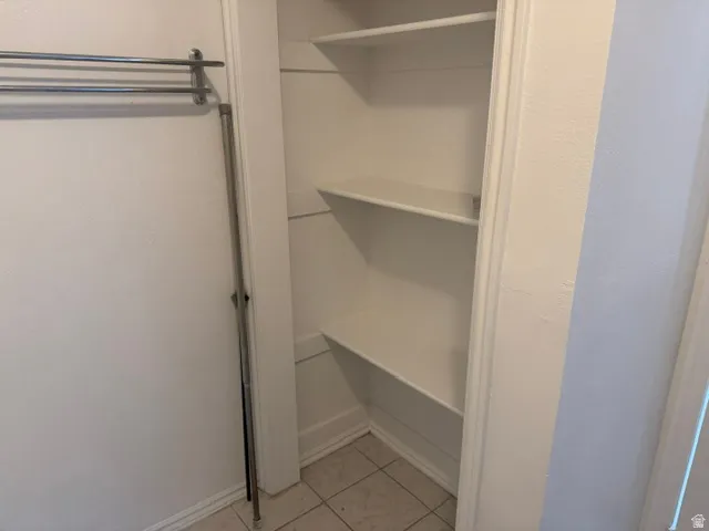 Integrated shelving system with multiple tiers, white painted finishes, and tile flooring