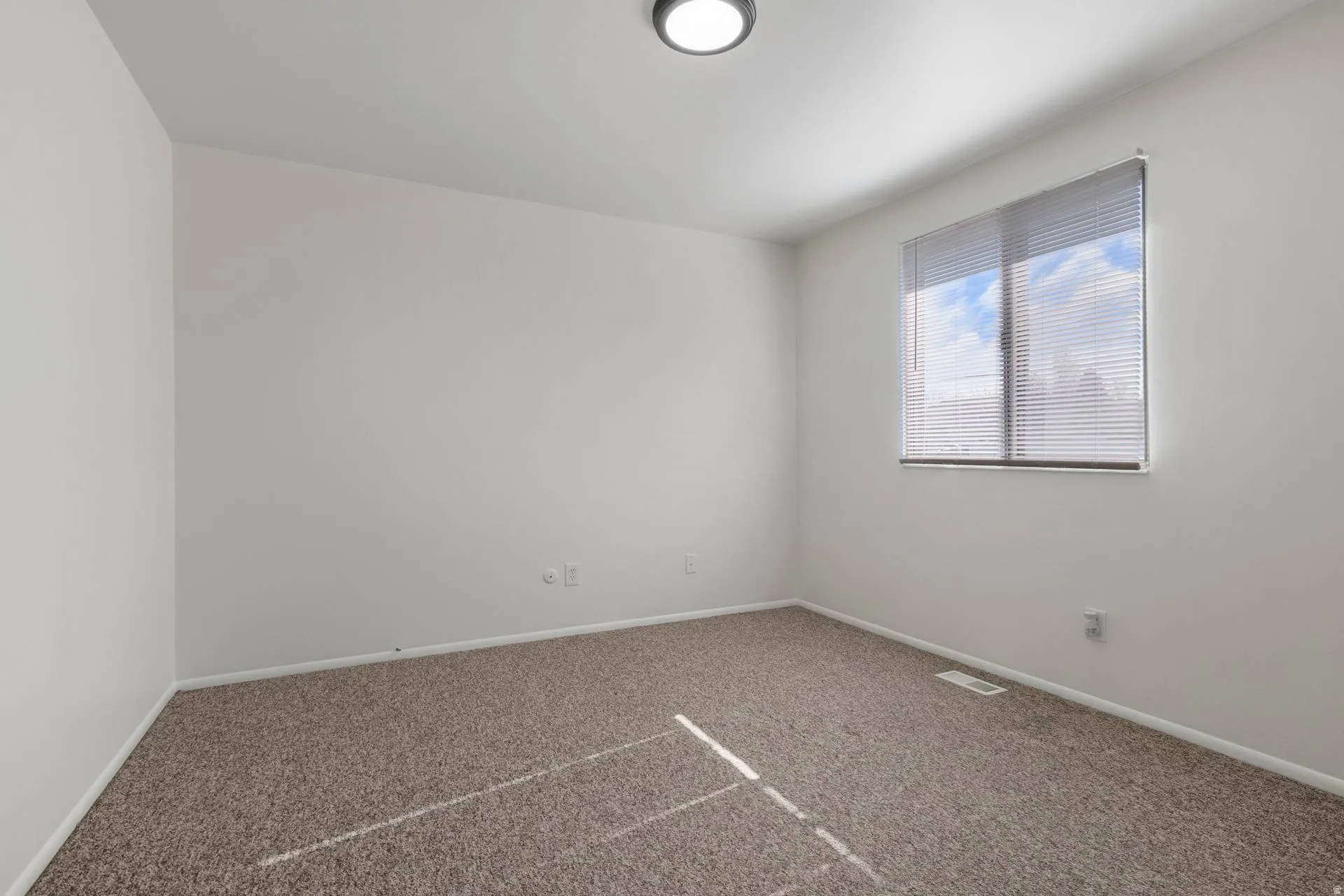 Carpeted empty room featuring baseboards