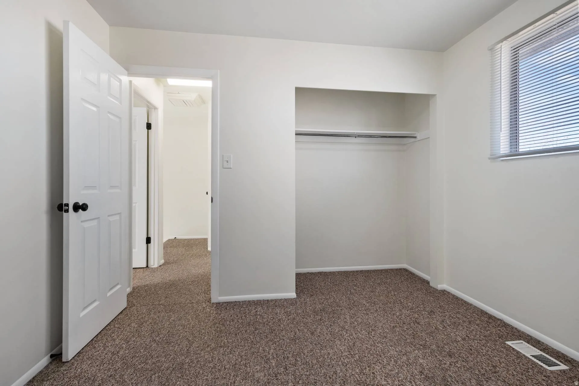 Unfurnished bedroom with dark carpet and a closet