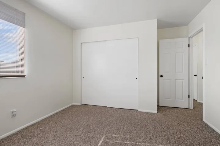Unfurnished bedroom featuring a closet and carpet floors