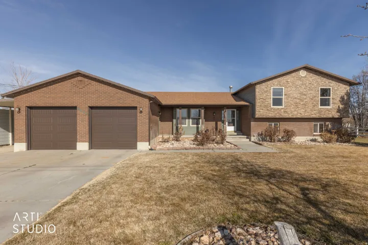 View of front of house with concrete driveway, a front lawn, and a garage