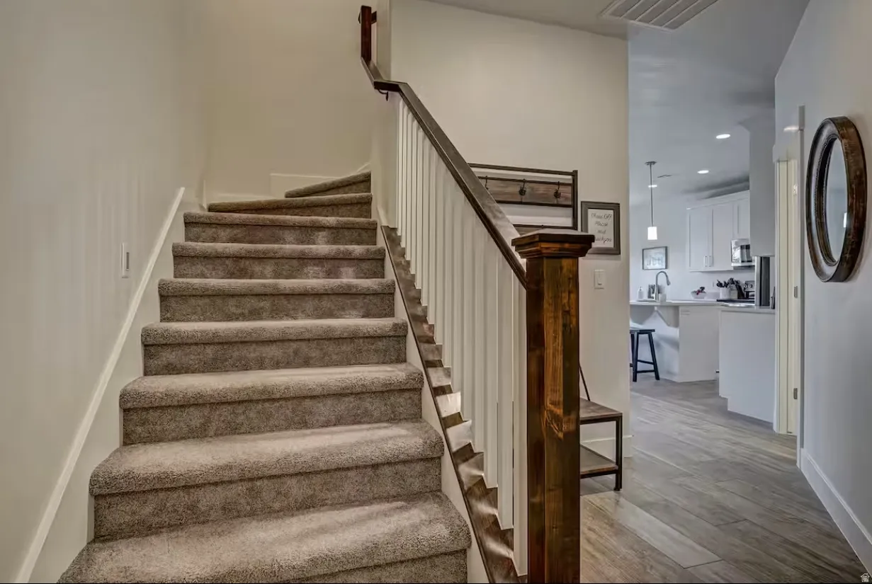 Stairway with recessed lighting and wood finished floors