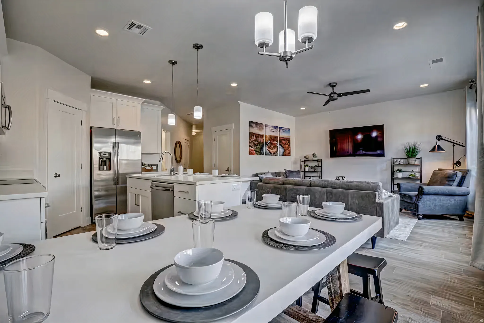Dining room featuring light wood finished floors, ceiling fan, and a chandelier