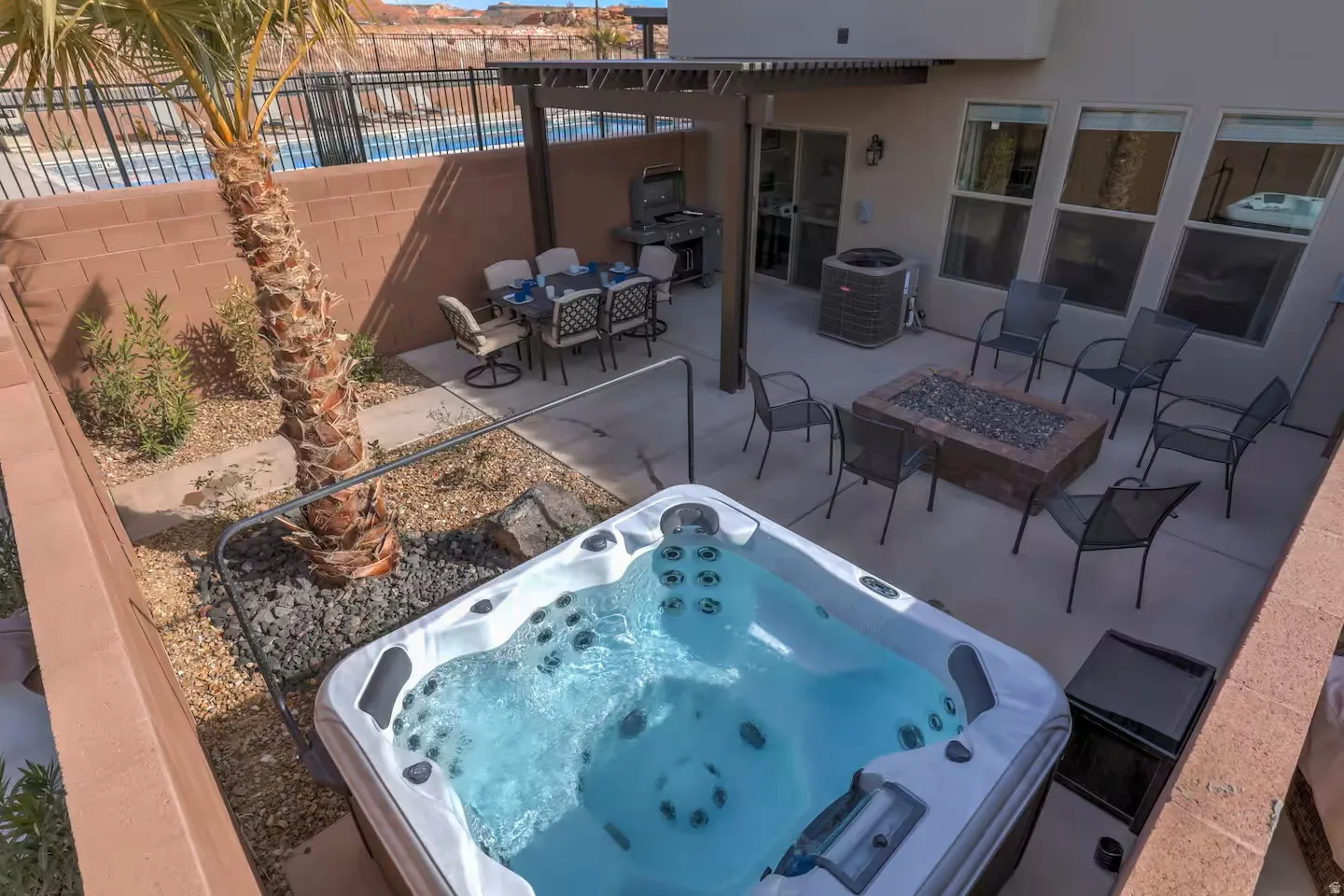 View of patio featuring outdoor dining area, an outdoor fire pit, a grill, and a hot tub