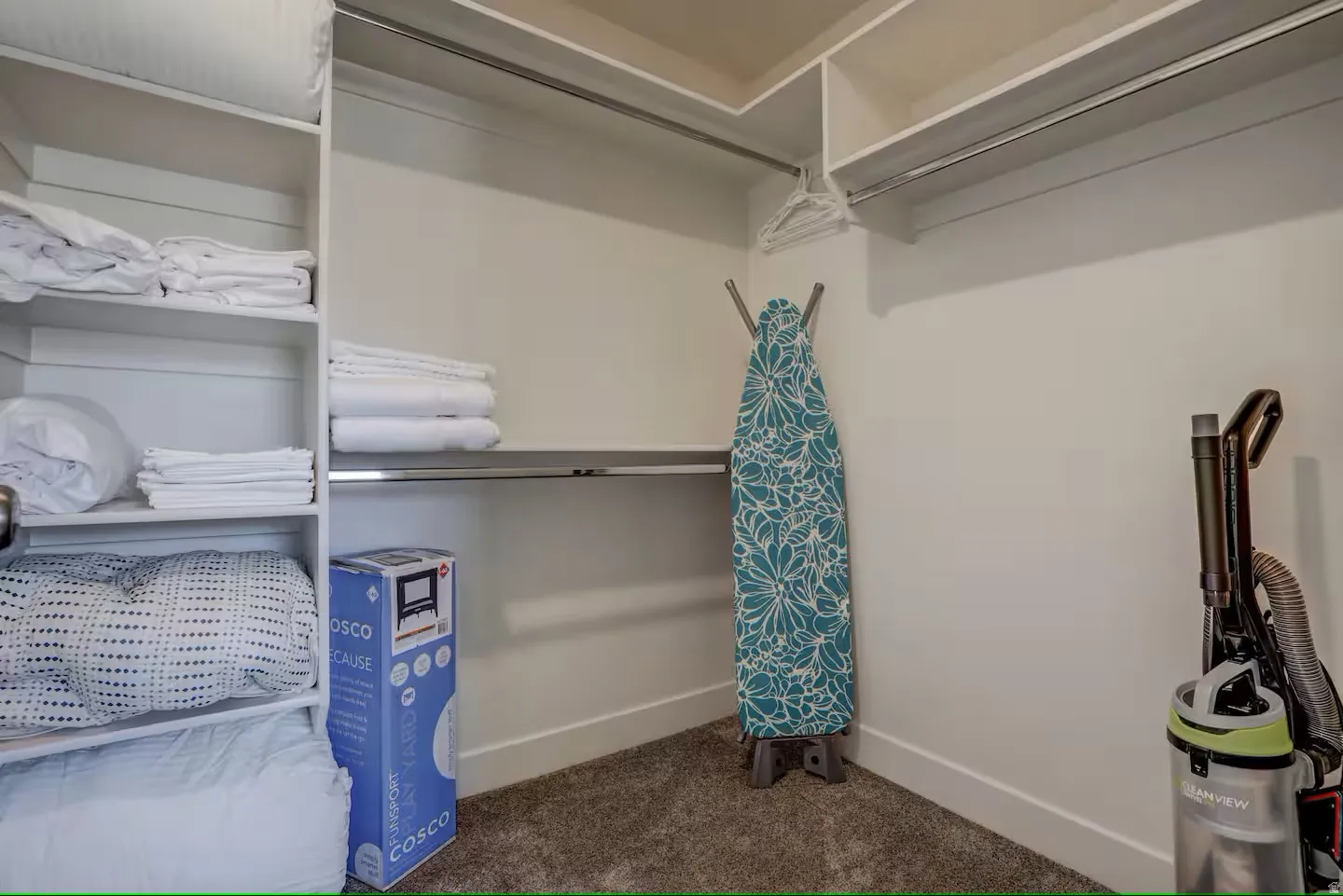 Walk in closet featuring dark colored carpet