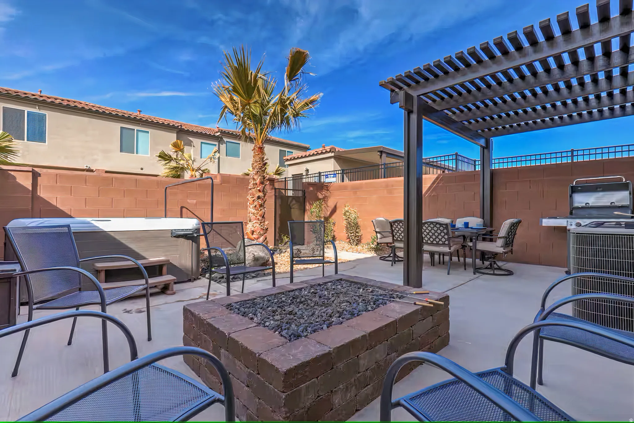 Fenced backyard with an outdoor fire pit, a pergola, a patio, outdoor dining space, and grilling area