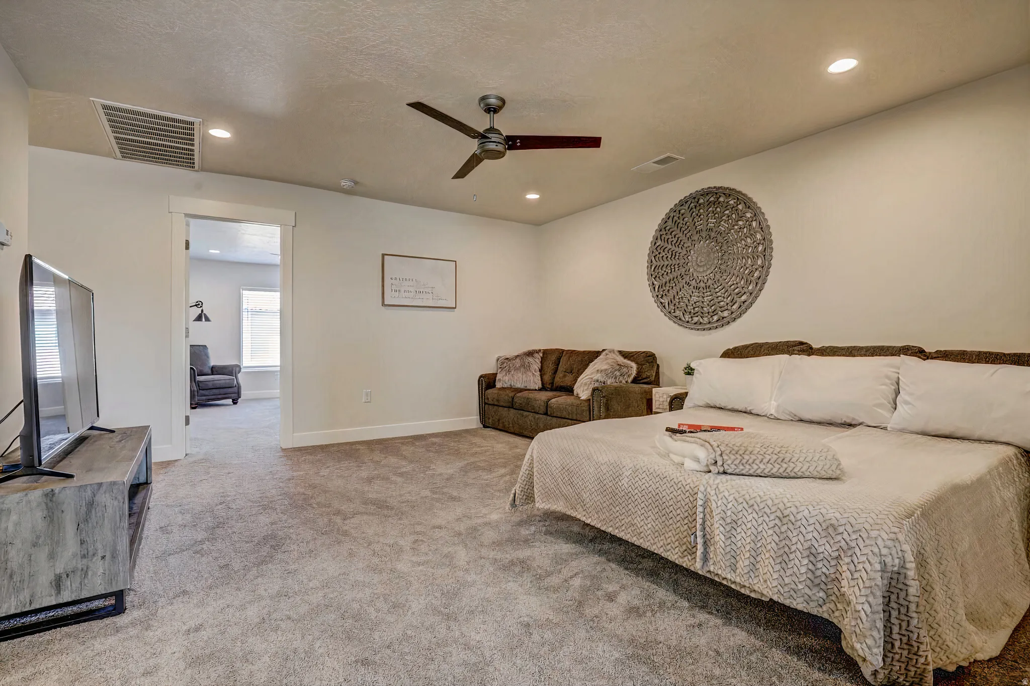 Bedroom with light carpet, a ceiling fan, and recessed lighting