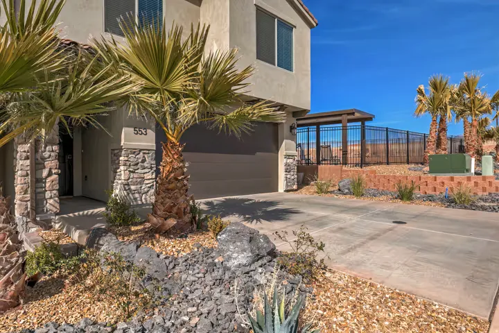 View of home's exterior with concrete driveway, stucco siding, stone siding, and an attached garage