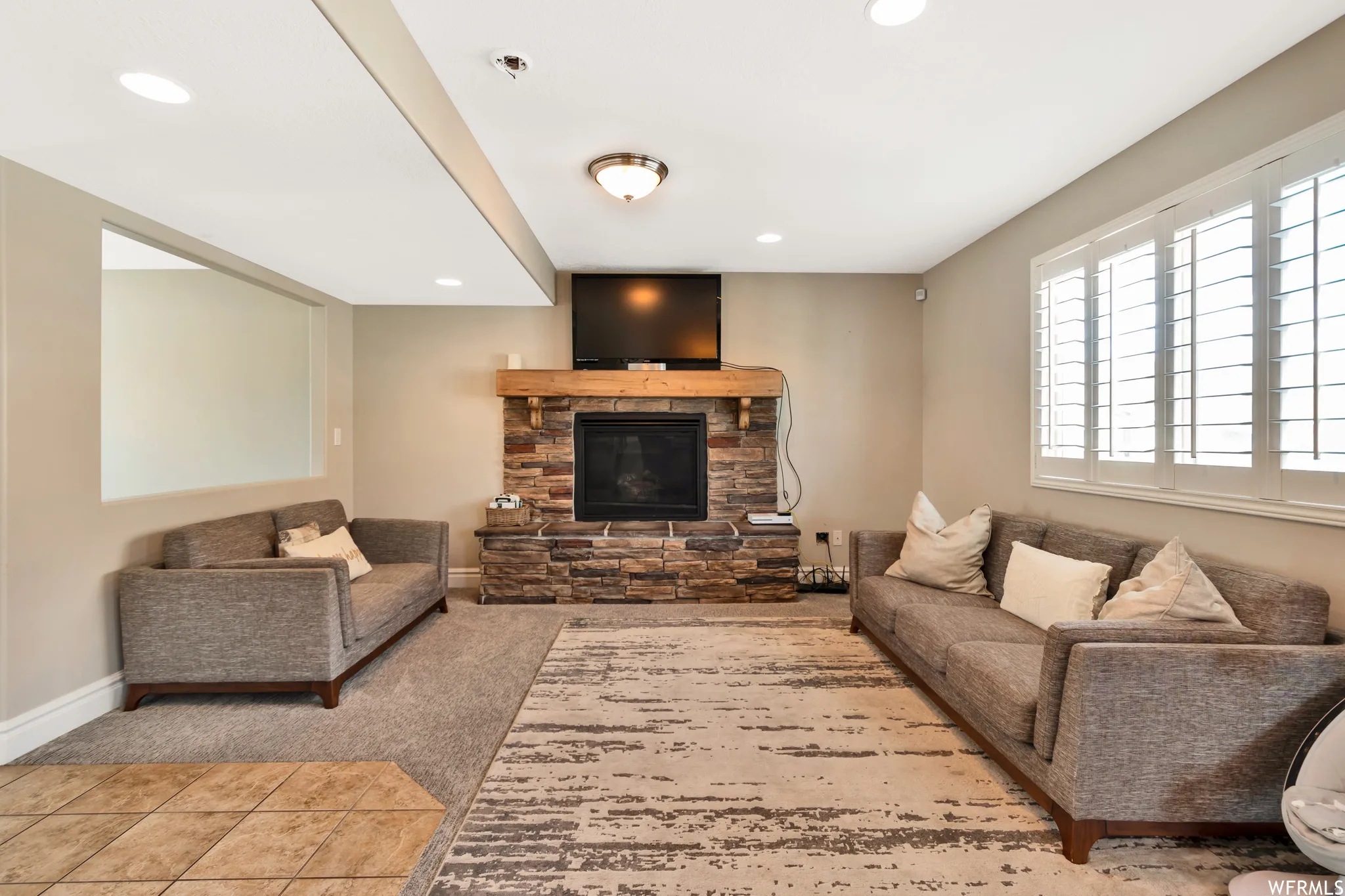 Carpeted living room featuring a fireplace and tile patterned flooring