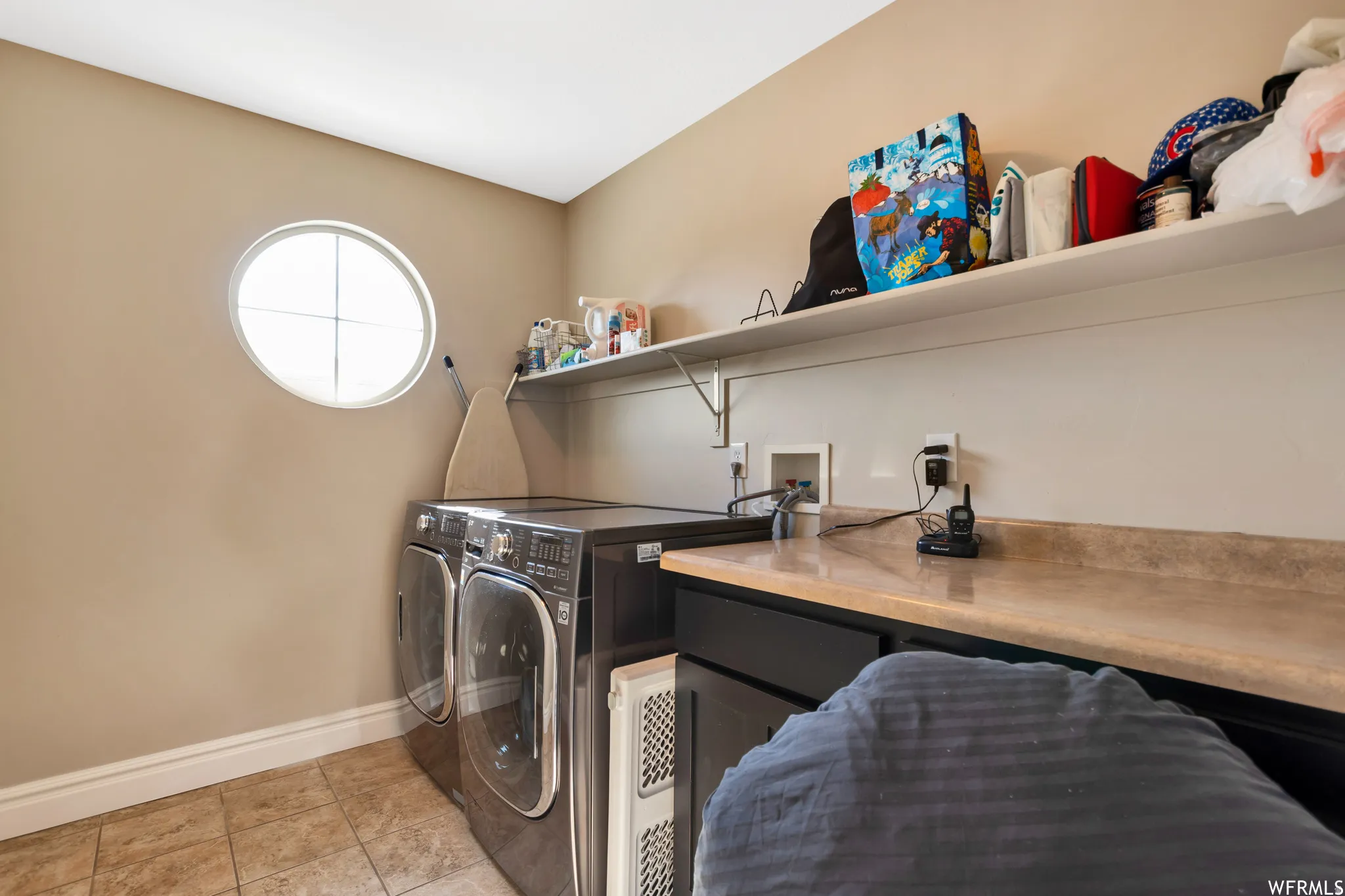 Laundry room featuring washing machine and clothes dryer and light tile patterned floors